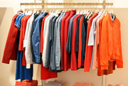 orange clothing in rack - security tags